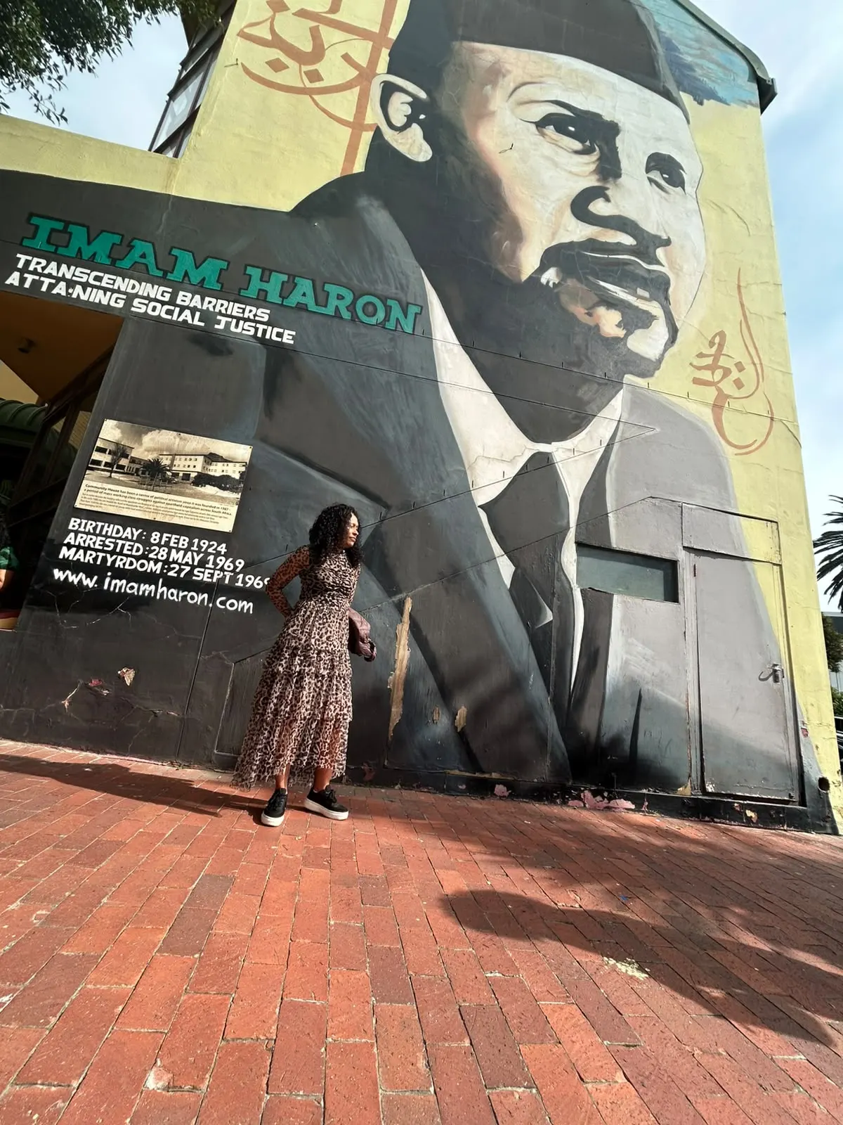 Candice Ohlson of Her Legacy Consulting standing at the Imam Haron heritage mural in Cape Town